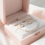 Coffret de bijoux élégant pour enfant, ouvert sur un tissu clair avec plusieurs bijoux délicats, ambiance douce et lumineuse.